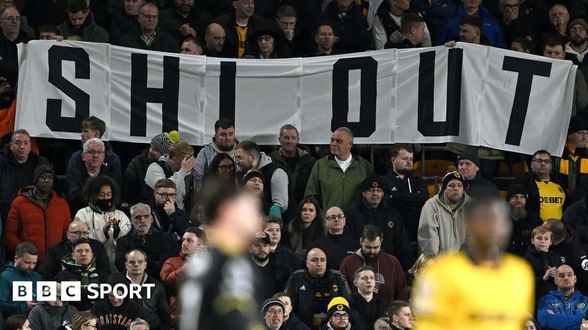 Wolves fans hold a Shi Out banner